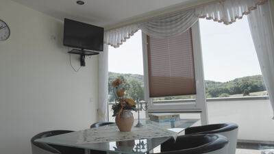Wohnraum einer Ferienwohnung mit Glastisch und Fensterblick