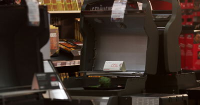 Supermarktkasse mit Aktionsschild im gedämpften Licht