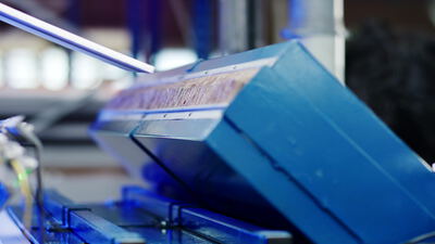 Geschreddertes Material auf der blauen Metallrutsche einer Maschine