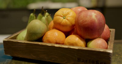Holzkiste mit frischem Obst steht auf einem Gartentisch