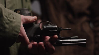 Hand zeigt einen Revolver mit geöffneter Trommel Hand zeigt einen Revolver mit geöffneter Trommel, Revolver Nahaufnahme, Revolver Trommel offen und Hand zeigt Revolver als