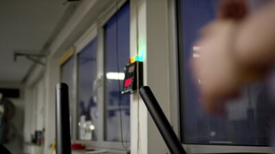 Person bedient einen Hebel an einer Prüfstation im Labor