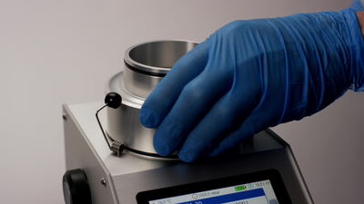 Filtertest an einem Messgerät im Labor mit blauen Handschuhen