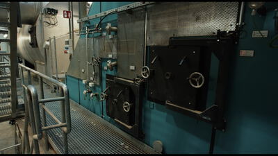 Industriemaschine mit Klappe und Handrad an einem Laufsteg