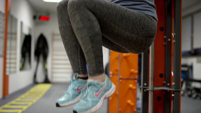 Person trainiert Beinheben an einer Station im Fitnessstudio