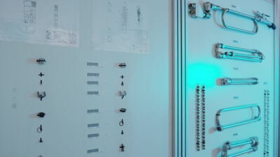 Technische Zeichnungen und Bauteile in einer Ausstellung präsentiert
