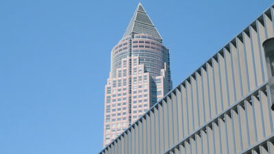 Die pyramidenförmige Spitze des Messeturms in Frankfurt vor blauem Himmel