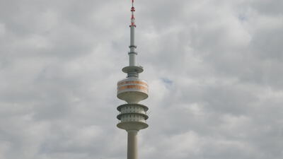 Olympiaturm ragt mit Antenne in den bewölkten Himmel über München: Olympiaturm, Olympiaturm München
