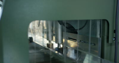 Automatisierte Industriemaschine bearbeitet ein eingespanntes Bauteil mit hellem Lichtpunkt