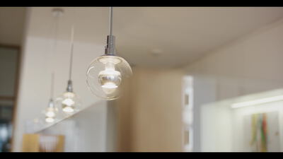Moderne Glaskugelleuchte hängt in hellem minimalistischem Innenraum