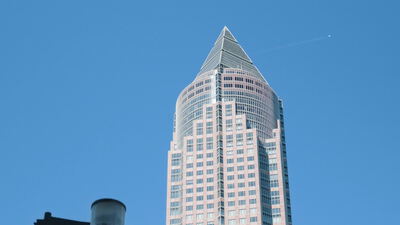 Messeturm in Frankfurt am Main mit pyramidenförmiger Spitze vor blauem Himmel