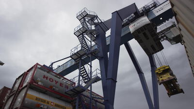 Portalkran hebt Spreader über Tankcontainer am Containerterminal Portalkran hebt Spreader über Tankcontainer am Containerterminal, Containerkran, Containerbrücke und Binnenhafen als 4K