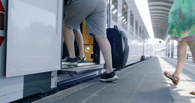 Fahrgäste steigen mit Koffer in den Doppelstockzug ein