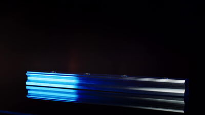 Aluminiumprofil als Linearschiene mit blauem Licht auf Schwarz