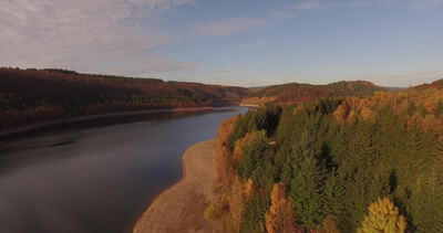 Luftaufnahme bewaldete Halbinsel in ruhigem herbstlichen Stausee