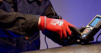 Facharbeiter präsentiert ein Messgerät an einem Arbeitstisch