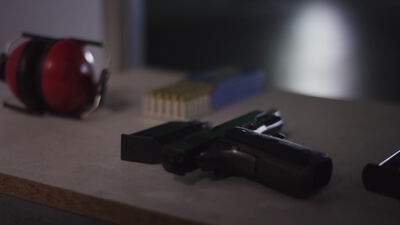Pistole und Munition auf der Bank im Schießstand, Pistole Schießstand, Munition Nahaufnahme und Schießstand Aufnahmen