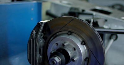 Bremsscheibe hängt am blauen Förderband in der Automobilfabrik
