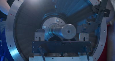 Rotorwelle eines Ventilators auf einer Auswuchtmaschine in blauem Licht