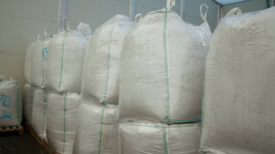 Weiße Big Bags auf Holzpaletten in der Lagerhalle