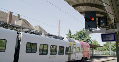 Regionalzug am Bahnsteig mit Abfahrtsanzeige und Signal