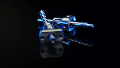 Gewindespindel und Flanschmutter als Präzisionsbauteil vor schwarzem Grund, Kugelgewindetrieb, Antriebstechnik und