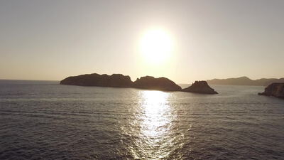 Sonnenuntergang über dem Meer mit silhouettenhaften Felseninseln
