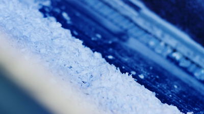 Weiße Kunststoffflocken als Makroaufnahme vor blauem Hintergrund