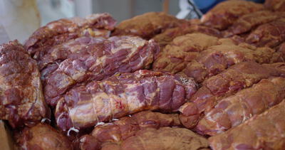 Gewürzte Rollbraten liegen dicht an dicht in der Fleischerei