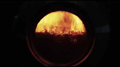 Loderndes Feuer im Schauglas einer industriellen Biomasse Feuerung