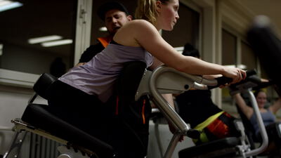 Menschen trainieren an Fitnessgeräten in einem Fitnessstudio