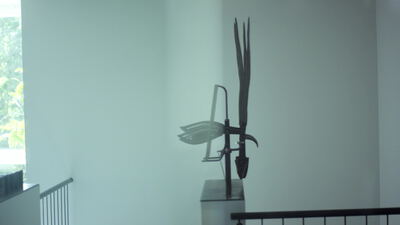 Metallskulptur auf einem Sockel in einem hellen Treppenhaus