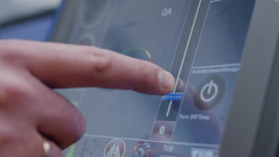 Hand bedient beleuchtetes Bedienfeld einer elektronischen Steueranlage in Nahaufnahme