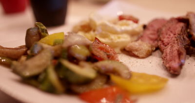 Gourmet Teller mit saftigen Steakscheiben und gegrilltem Gemüse