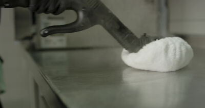 Dampfstrahl trifft auf weißen Schaumberg auf dem Tisch