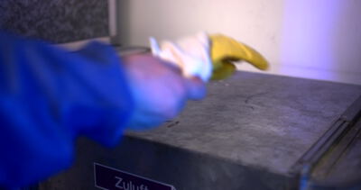 Schutzhandschuhe trocknen auf einem metallenen Zuluftkanal