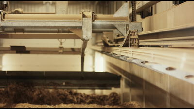 Industrielle Förderanlage mit losem braunem Material in der Halle