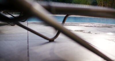 Poolabdeckung gleitet am Morgen langsam über das blaue Schwimmbecken
