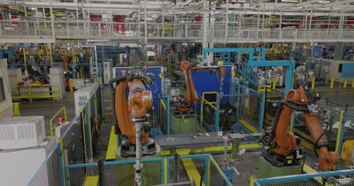 Orangefarbene Industrieroboter arbeiten in einem großen Automobilwerk