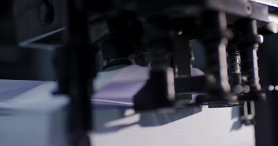 Industrielle Druckmaschine trägt Farbe auf Papierbögen auf