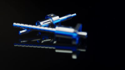 Blaues eloxiertes Präzisionsinstrument vor schwarzem Hintergrund Blaues eloxiertes Präzisionsinstrument vor schwarzem Hintergrund, eloxiertes Metall, chirurgisches Instrument und
