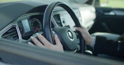 Autofahrerin greift mit beiden Händen ans Lenkrad