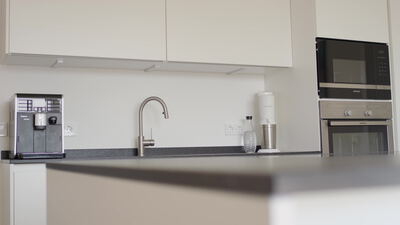 Moderne Küche mit Kaffeevollautomat und Einbaubackofen