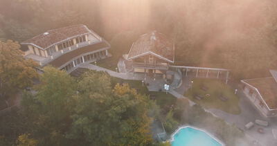 Drohnenaufnahme eines Hauses mit Pool im goldenen Morgenlicht