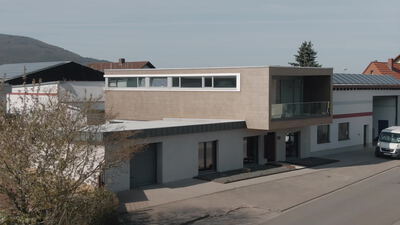 Modernes Gewerbegebäude mit Lieferwagen an einer Straße