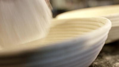 Teigling ruht im gerillten ovalen Gärkörbchen der Backstube, Teigling im Gärkörbchen, geripptes Gärkörbchen und ovales