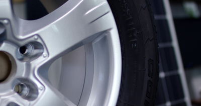 Solarzellen im Detail neben einer Autofelge in der Werkstatt