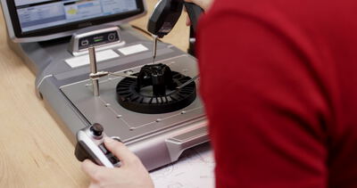 Arbeiter in Rot bedient eine Messstation mit Handscanner