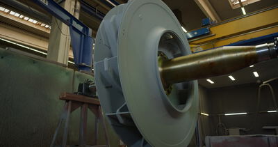 Großer Industrieventilator mit Antriebswelle steht in der Werkhalle
