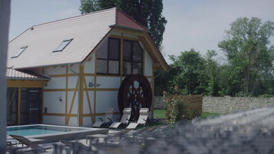 Fachwerkhaus mit Mühlrad und Pool im sonnigen Garten